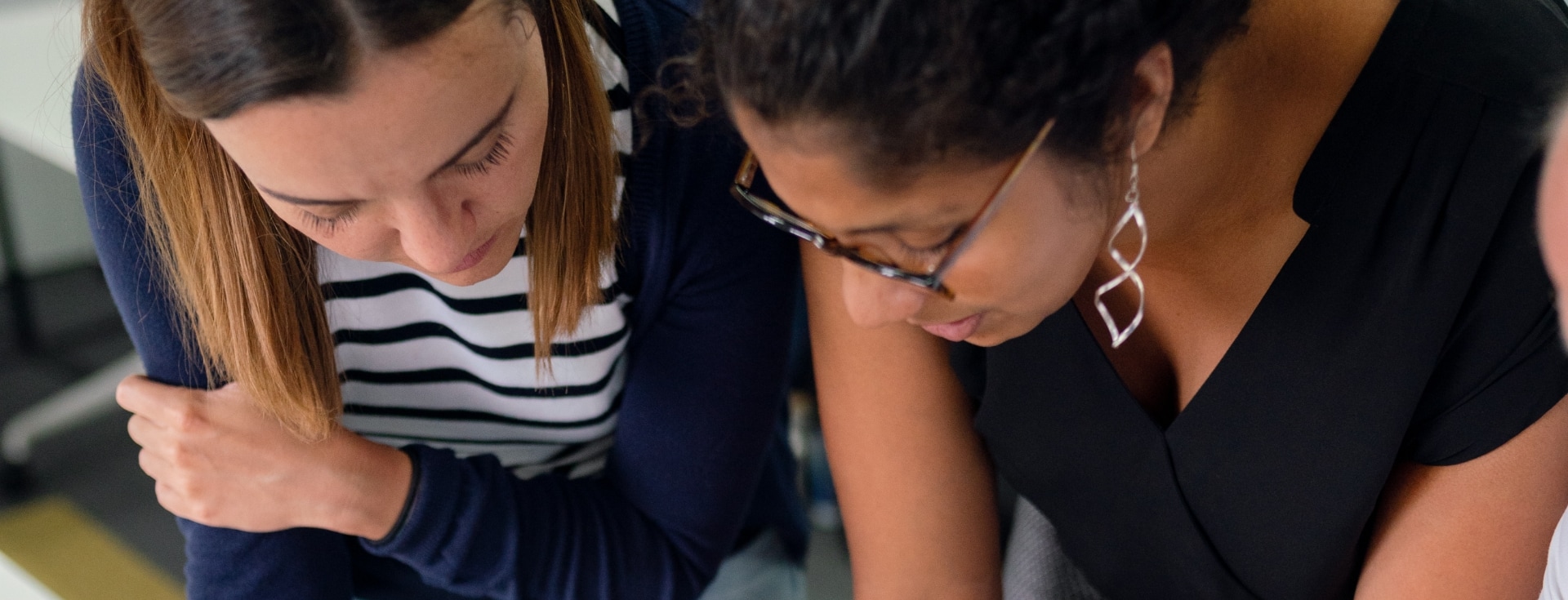 Chicas revisando algo en una mesa